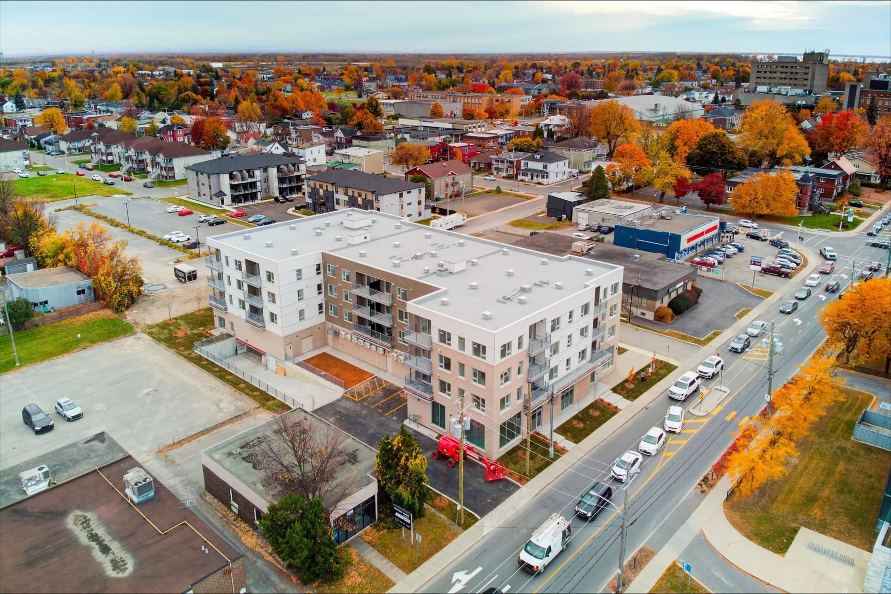 Vue aérienne de l'immeuble dans son îlot, arbres d'automne et rues environnantes